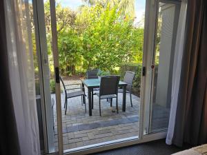 a table and chairs on a patio with a sliding glass door at Cozy water side apartment - Jetty in Mandurah