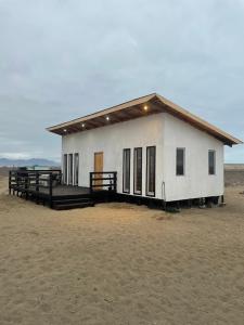 a small white building in the middle of the desert at Rincon del desierto lodge in Punta de Choros