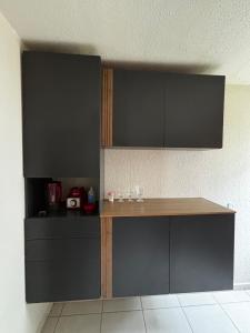 a kitchen with black cabinets and a wooden table at Prince House in Piracicaba