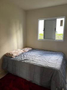 a bed in a bedroom with a window at Prince House in Piracicaba