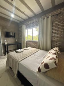 a bedroom with a large bed and a window at Chalé Florada d' Serra in Chapada dos Guimarães