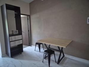 a wooden table in a room with a stool at Laureles del parque loft in Barranquilla
