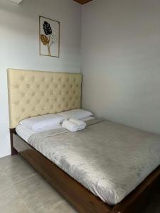 ein Bett mit zwei Handtüchern darauf in einem Zimmer in der Unterkunft JB Inn in Migcanauay + 2 Fotos