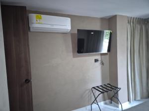 a room with a heater and a television on the wall at Laureles del parque loft in Barranquilla +3 photos