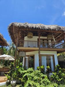 a house with a thatched roof with a patio at Pangaro House in Katiet +17 photos