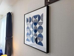 a picture on a wall with a framed picture of shells at BALCOM STAY Hiroshima Takasu in Hiroshima