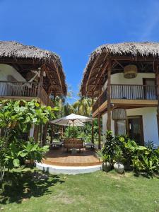 a house with a bench and an umbrella in the yard at Pangaro House in Katiet