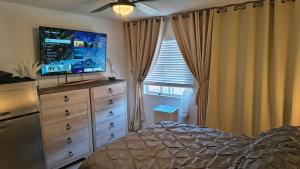 a bedroom with a dresser with a television on it at Golden House in Santa Clarita