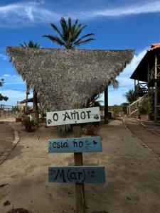 a sign in front of a hut with a thatched roof at Apto tipo Studio de temporada no litoral Piauí in Parnaíba