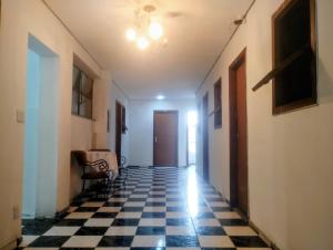 a hallway with a black and white checkered floor at Hotel BH Center in Belo Horizonte