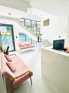 a living room with pink furniture and a tv at LA VILLA by luxury Attilan in San Pedro La Laguna