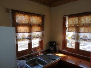a kitchen with a sink and two windows at Cabañas El Ensueño in La Ciudad +11 photos