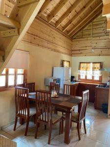 a kitchen with a wooden dining table and chairs at Cabañas El Ensueño in La Ciudad