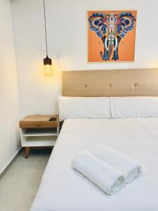 a bedroom with a white bed and a night stand at LA VILLA by luxury Attilan in San Pedro La Laguna