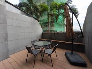 a patio with a table and chairs and an umbrella at Lido De Paris Hotel in Manila