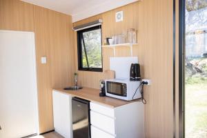 a small kitchen with a microwave on a counter at Beckford Tiny House 2 by Tiny Away in Good Hope