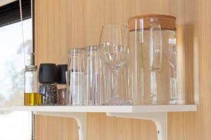 a shelf with glasses sitting on top of it at Beckford Tiny House 2 by Tiny Away in Good Hope
