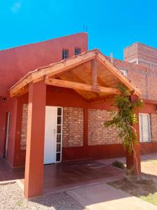 a brick building with a wooden pergola on it at HOTEL FINCA AMANCAY in Villa Unión