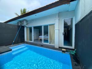 a swimming pool in front of a house at Villa Kulat in Uluwatu