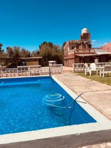 a swimming pool in front of a house at HOTEL FINCA AMANCAY in Villa Unión