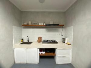 a kitchen with a sink and a counter top at Villa Kulat in Uluwatu