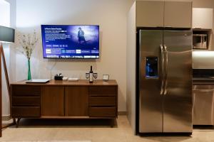 a kitchen with a desk with a refrigerator and a tv at Pavilion 307 in Puerto Vallarta