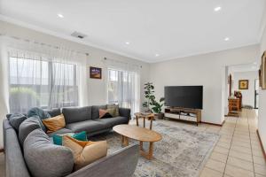 a living room with a couch and a tv at 10 Rupara Family Beach House with Sea Views Linen Included in Hayborough