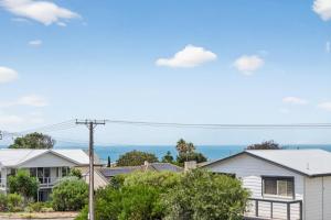 a row of houses with the ocean in the background at 10 Rupara Family Beach House with Sea Views Linen Included in Hayborough