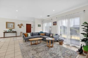 a living room with a couch and a table at 10 Rupara Family Beach House with Sea Views Linen Included in Hayborough
