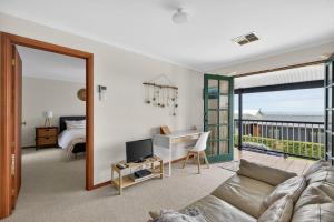 a living room with a couch and a desk at 10 Rupara Family Beach House with Sea Views Linen Included in Hayborough