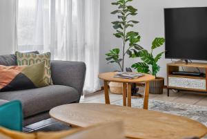 a living room with a couch and a tv at 10 Rupara Family Beach House with Sea Views Linen Included in Hayborough +32 photos