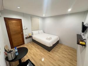 a small room with a bed and a desk at บ้านสุดซอย-Baan Sud Soi in Prachuap Khiri Khan