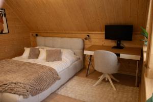 a bedroom with a bed and a desk with a computer at Domek w sam las in Ochotnica Dolna +23 photos