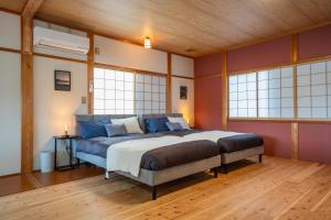a bedroom with a large bed in a room with windows at Oceanfront Up to 14 Guests BBQ Available オーシャンフロント小浜田烏 in Obama