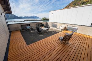 a wooden deck with a table and chairs on it at Oceanfront Up to 14 Guests BBQ Available オーシャンフロント小浜田烏 in Obama