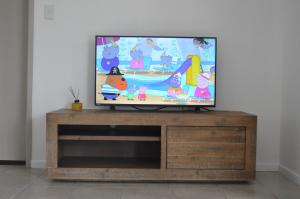 a flat screen tv sitting on top of a wooden entertainment center at James Street Motor Inn in Toowoomba