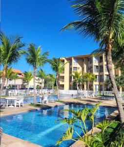 a pool at the resort with palm trees at Aldeia dos reis - Condado - Mangaratiba - Loft 405 bl 3 in Mangaratiba