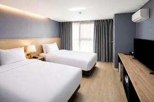 a hotel room with two beds and a flat screen tv at Hotel Bernoui Seoul in Seoul +24 photos