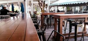 a bar with wooden tables and chairs in a restaurant at Mamutik Island Lodge in Kota Kinabalu