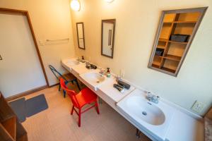 a bathroom with two sinks and a red chair at Oceanfront Up to 14 Guests BBQ Available オーシャンフロント小浜田烏 in Obama +49 photos