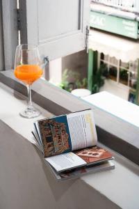 a book and a glass of orange juice and a drink at Non Inn The Diamond Artisan and Barber 4 Bedroom Riverside Retreat with King and Twin Rooms in Bang Rak
