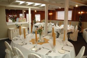 a dining room with white tables and white chairs at Delta King Hotel in Sacramento