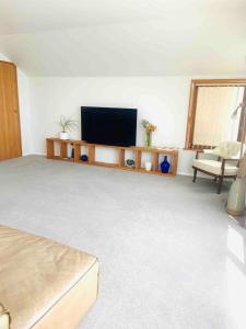 a living room with a flat screen tv and a chair at Nelson Harbour View in Nelson