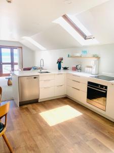 a kitchen with white cabinets and a sink at Nelson Harbour View in Nelson