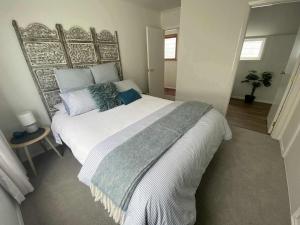 a bedroom with a large white bed with pillows at Nelson Harbour View in Nelson