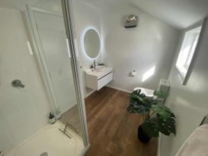 a bathroom with a shower and a sink and a mirror at Nelson Harbour View in Nelson +22 photos