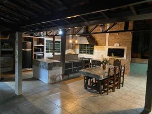a kitchen with a wooden table and a dining room at Villa Domus in Barretos
