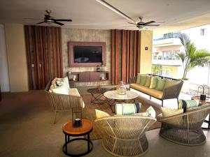 a living room with couches and tables and a television at Pavilion 307 in Puerto Vallarta