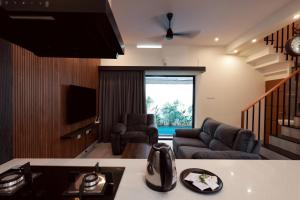 a living room with a couch and a tv at G' de CASA in Varkala