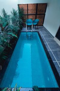 a swimming pool with a table and two chairs next to it at G' de CASA in Varkala